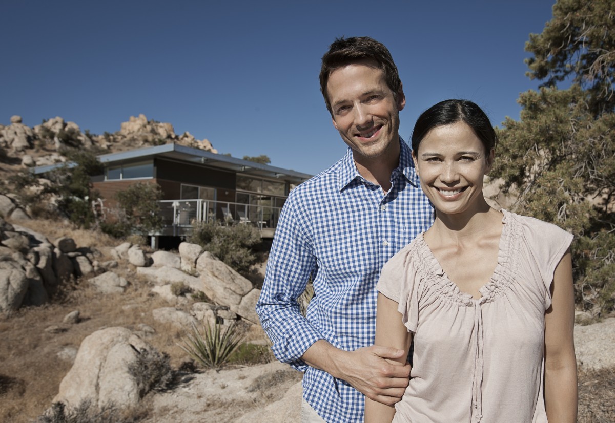 Smiling couple outside modern desert home